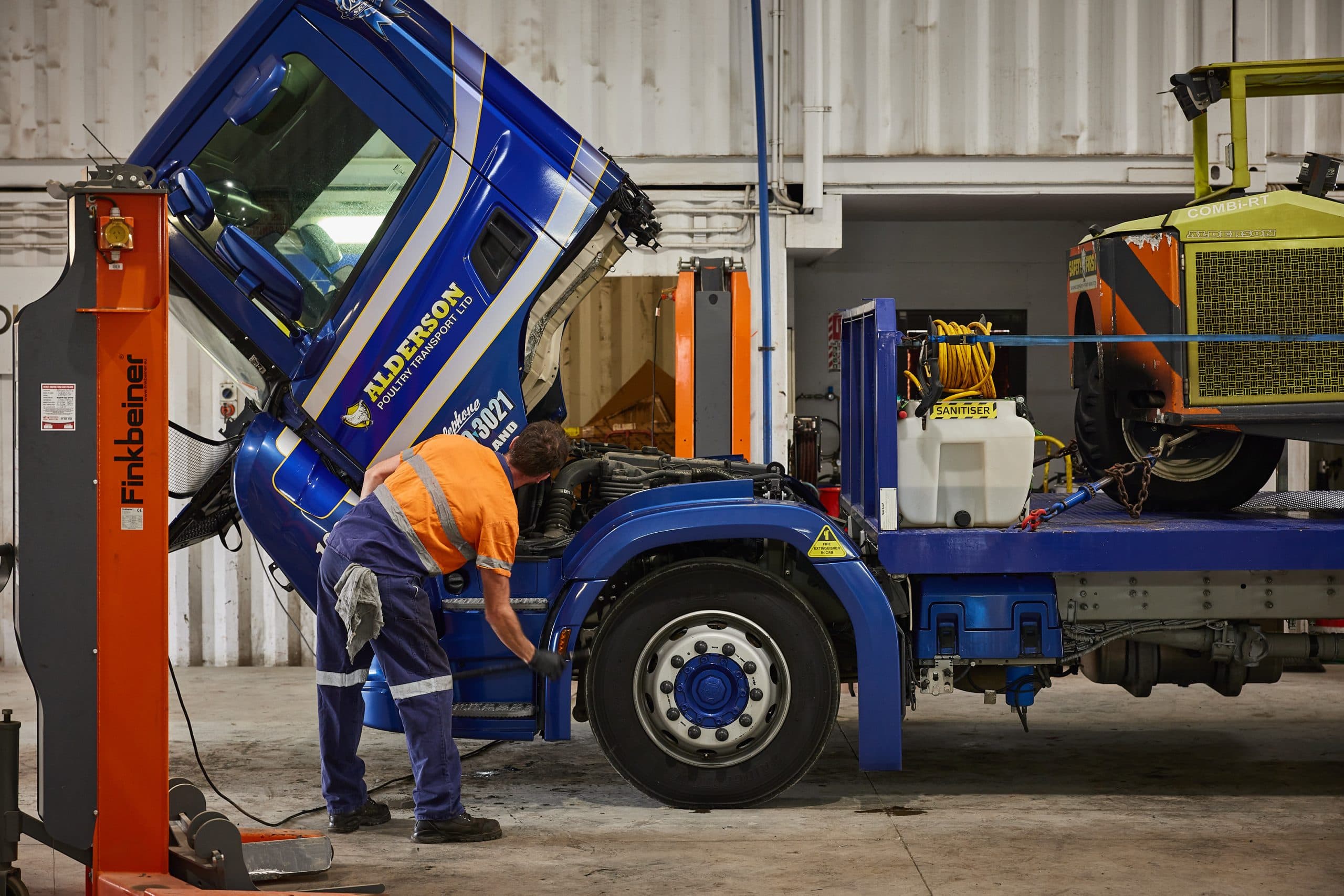 A mechanic working on a large semi truck engine.